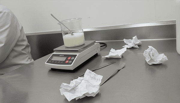 A chemist in a lab coat carefully mixing ingredients in a beaker, developing a unique cosmetic formula.