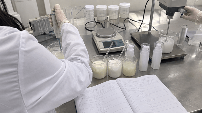 R&D lab workstation with formulation samples, pipettes, and stability testing logbook
