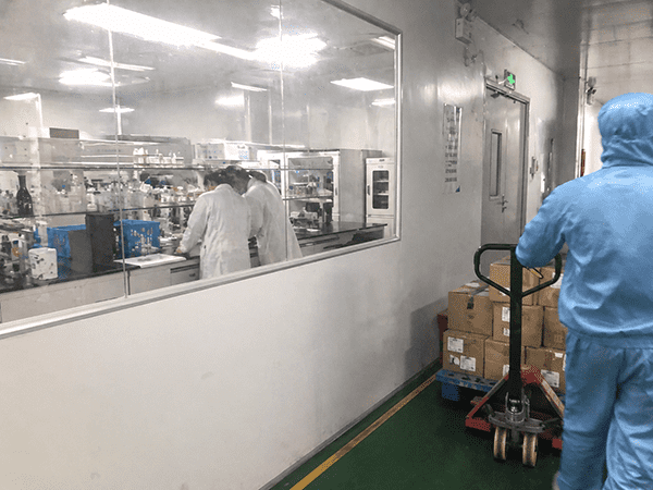 A scientist in a lab coat holding a beaker contrasted with a factory worker on a production line.