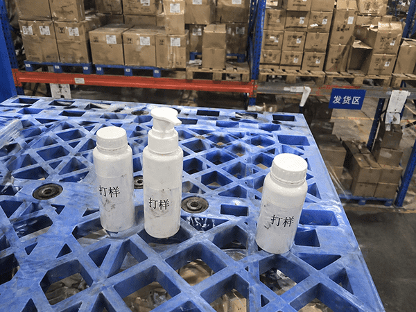 An image showing a single, expensive-looking bottle next to a large pallet of cost-effective bottles.
