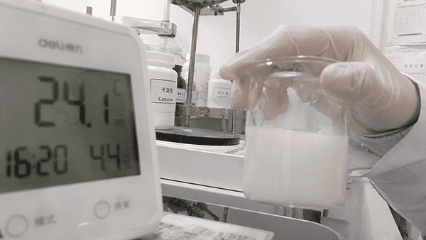 A scientist inspecting a cosmetic formula in a lab beaker