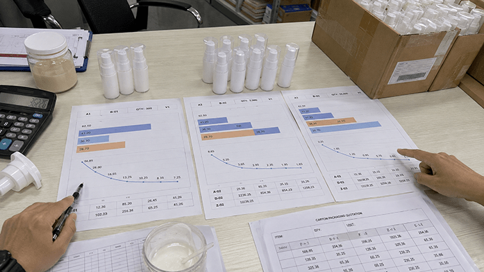 Cost structure comparison showing fixed batch costs — setup, testing, and packaging minimums — amortizing differently across a few hundred, 2,000, and 5,000 unit runs, with per-unit cost falling as volume rises