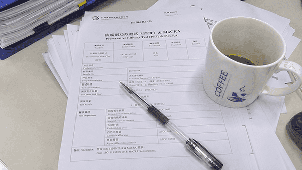 Beauty Product Compliance Documentation A stack of compliance and quality control documents on a desk