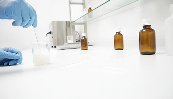 A cosmetic chemist mixing ingredients in a lab beaker