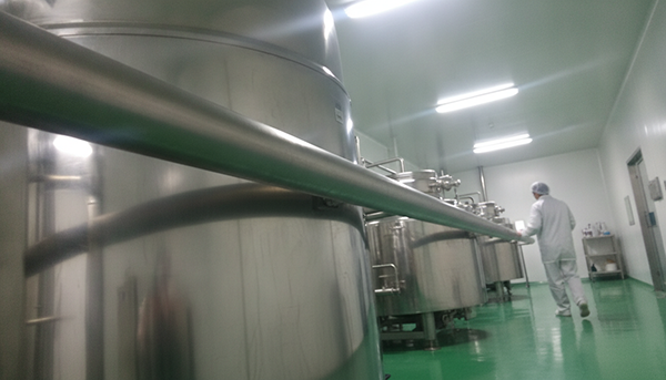 Large stainless steel mixing vats in a cosmetic factory
