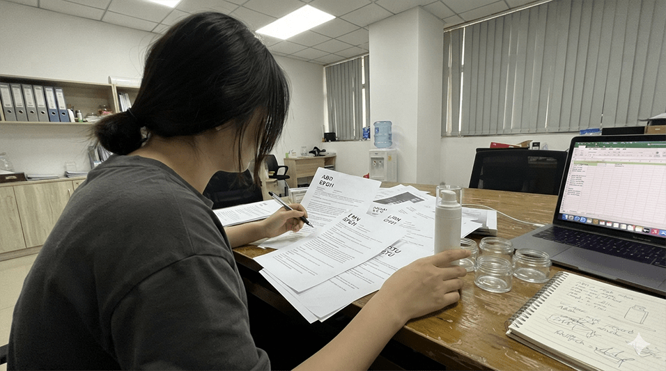 A beauty brand founder reviewing resumes for cosmetic product development jobs in a modern office