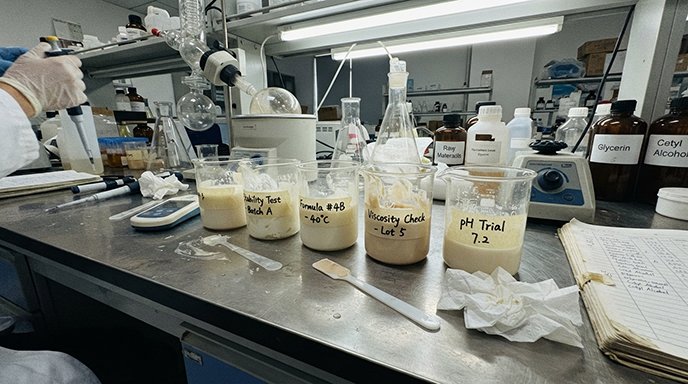 a scientist is looking at a cosmetic formula in a beaker