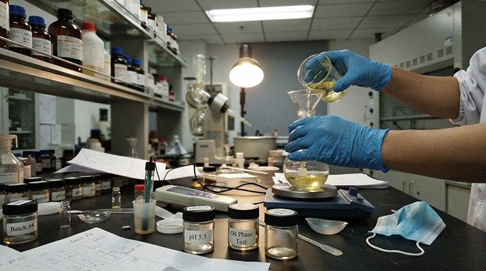 The Science Behind Cosmetic Formulation in Practice A cosmetic chemist carefully mixing ingredients in a laboratory beaker, representing the science behind cosmetic formulation.