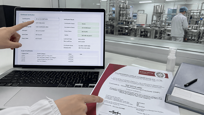 ISO 22716 certificate verification page on laptop with printed certificate beside it, iPhone-angle snapshot